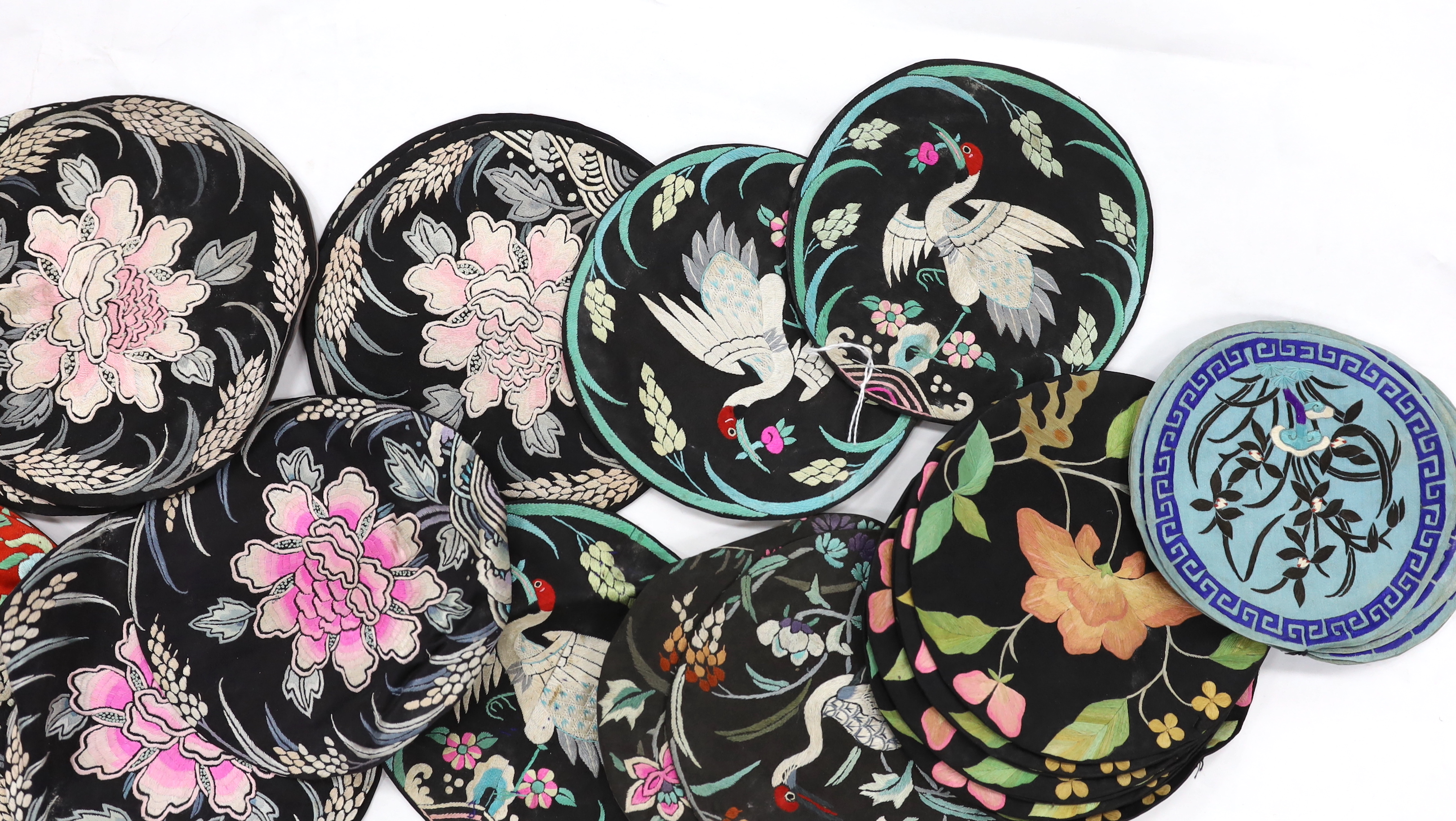 Four sets of eight circular Chinese silk embroidered mats and a set of three similar mats, all depicting birds and stylistic flowers